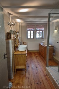 Full bathroom with old style wash-bowl. Spacey shower to the right.